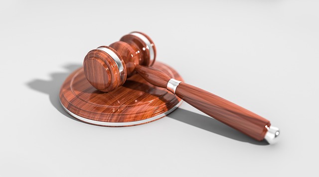 A wooden judge's gavel resting on a sound block