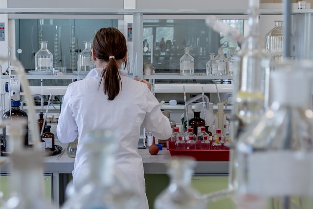 A woman in a lab coat working inside a chemistry laboratory