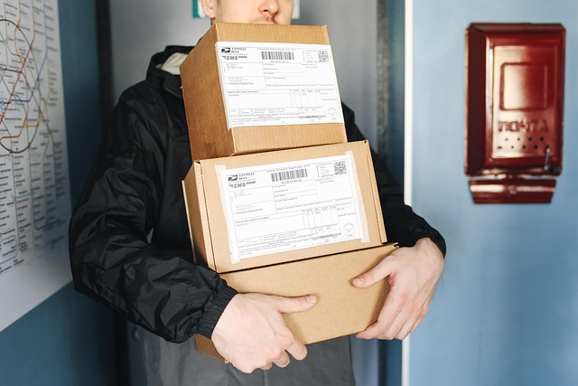 A courier holding a stack of cardboard packages with shipping labels