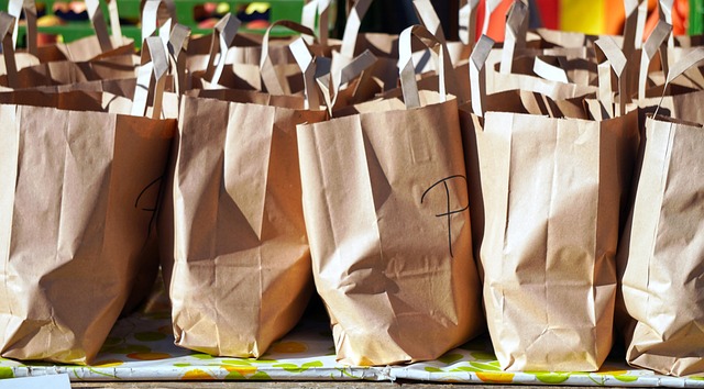 Multiple brown paper shopping bags lined up on a table