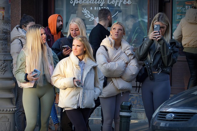 A group of people standing in line on a city street