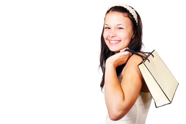 A smiling woman holding a shopping bag over her shoulder