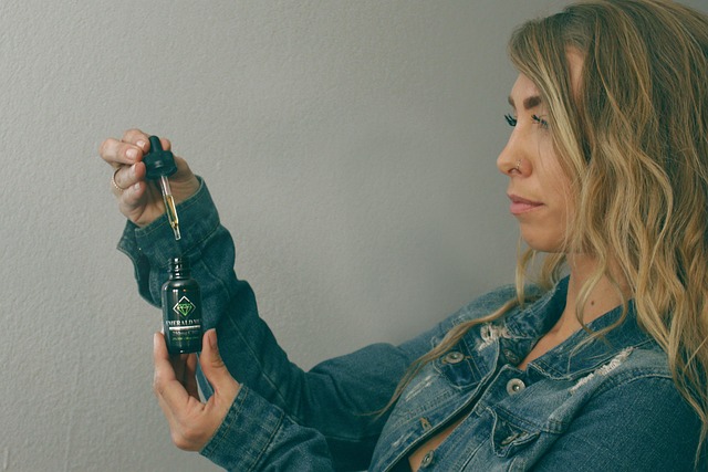 A woman holding a bottle of CBD tincture and a dropper