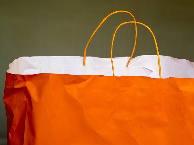 An orange paper shopping bag with handles